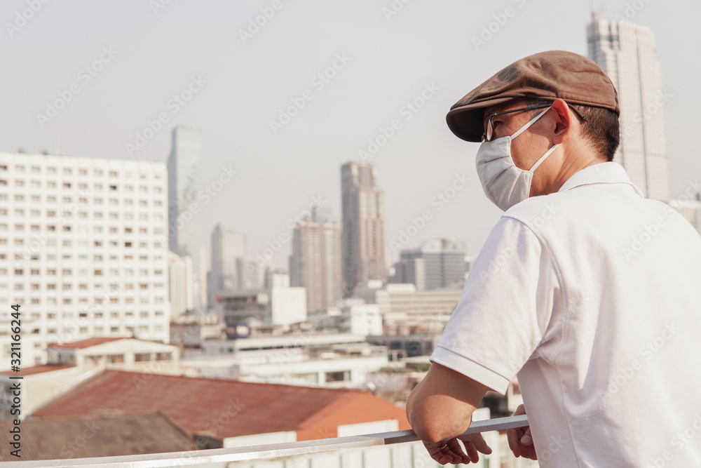 Middle aged Asian man wearing medical face mask,coronavirus covid-19 virus pandemic, self quarantine, social distancing, self isolation,air pollution and health concept
