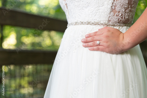 Bride with hands on hips showing off wedding ring