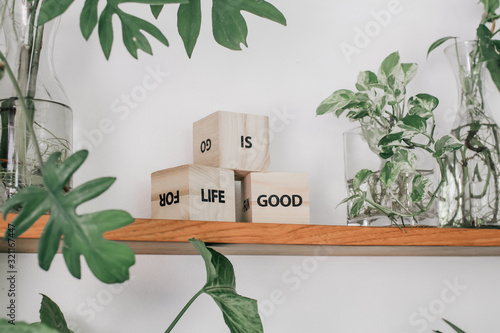 Good morning vintage style photo (filter) of three wooden cubes with words Enjoy, Good, Life with green background. Affirmational, positive and motivational quote photo