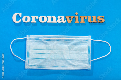 Coronavirus phrase text on a blue background with protective mask.