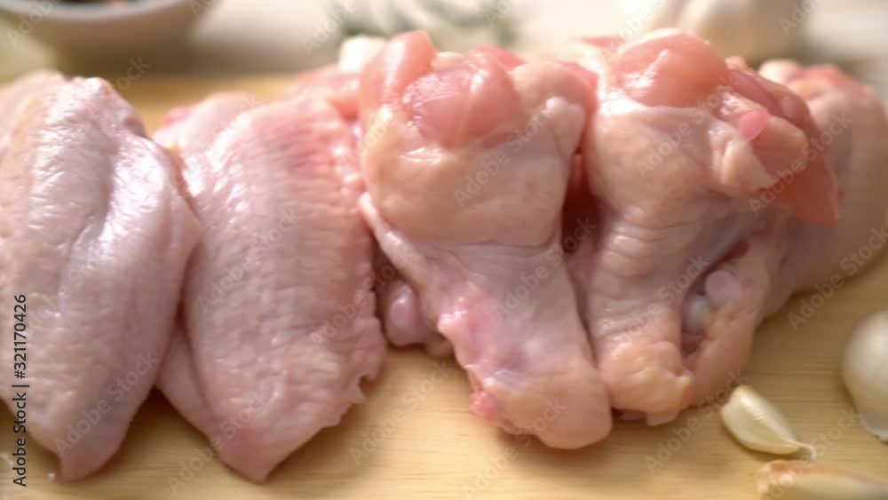fresh raw chicken wings on wooden board with ingredients fresh raw chicken wings on wooden board with ingredients