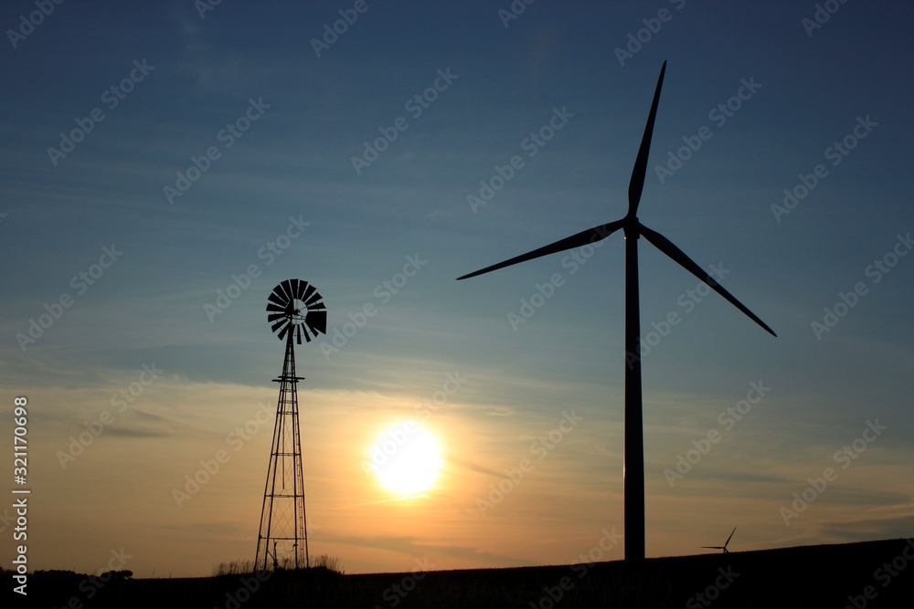 Obraz premium wind turbines at sunset with a Kansas Country Windmill.