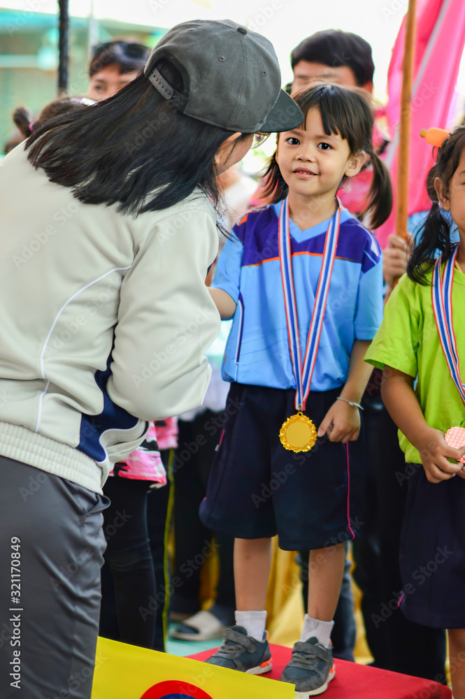 Obraz premium The winner, The girl get the gold medal that won from sports competitions with sport day in school events.
