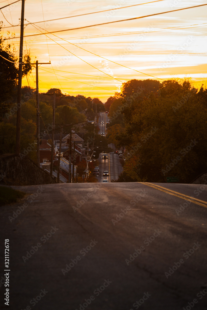 Road in Maryland, USA in Evening Light with yellow Sky and Cars with Headlights - Copy Space