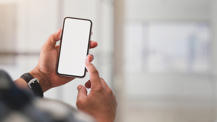 Close up view of a man using blank screen smartphone