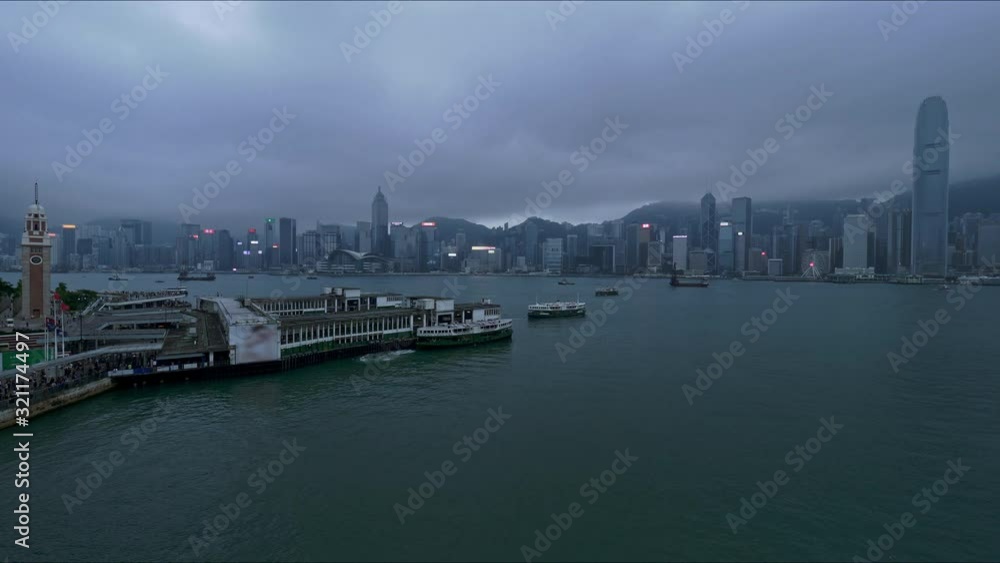Skyline of Hong Kong island as seen from Kowloon waterfront at dusk under moody skies. Locked wide shot Skyline of Hong Kong island as seen from Kowloon waterfront at dusk under moody skies. Locked wide shot