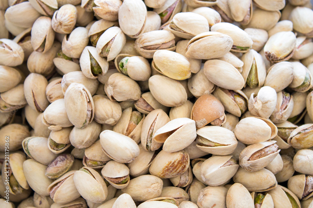 Pistachios are scattered on the table. Background for design