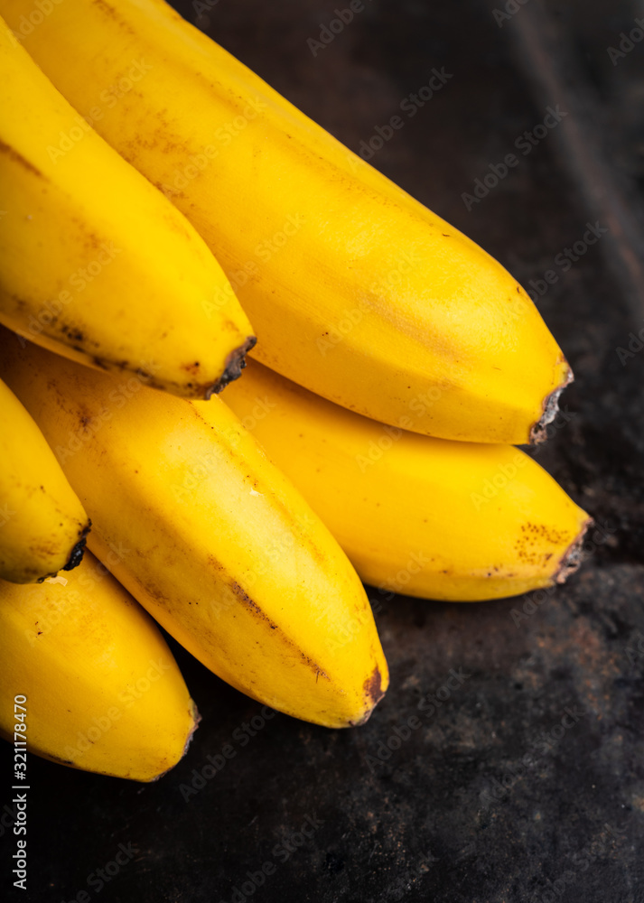Branch of bananas on the rustic background. Selective focus. Shallow depth of field.
