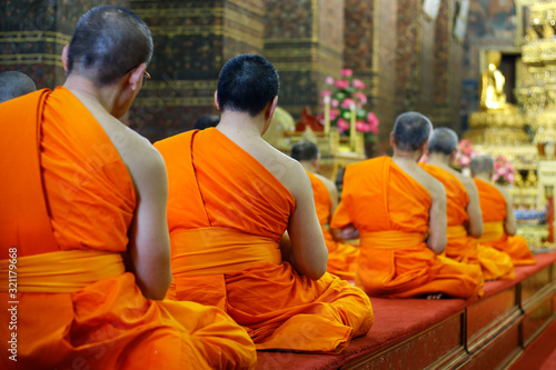 фотографія heads of monk praying in buddhist temple