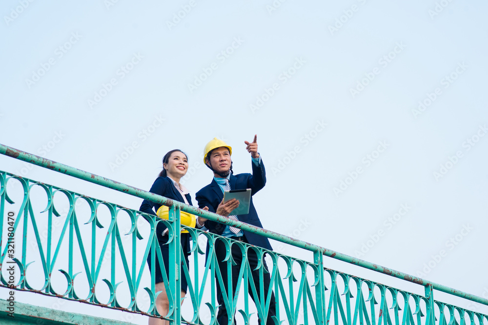 Asian engineer was acting with his secretary on the Business building background. Asian engineer was acting with his secretary on the Business building background.