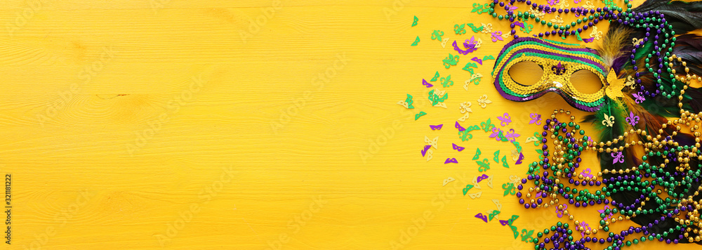 Holidays image of mardi gras masquarade venetian mask over yellow background. view from above - obrazy, fototapety, plakaty 