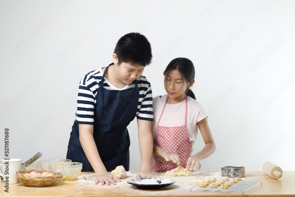 Asian preteen boy and girl preparing dough for making bread or pizza, lifestyle concept. Motion blur. Asian preteen boy and girl preparing dough for making bread or pizza, lifestyle concept. Motion blur.