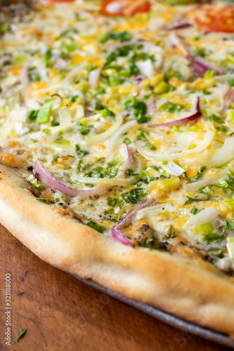 A closeup view of a veggie pizza, featuring several varieties of onions.