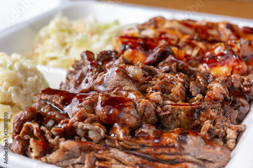 A closeup view of a container of teriyaki beef and teriyaki chicken in a restaurant or kitchen setting.