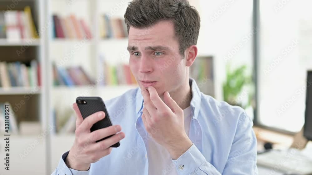 Upset Young Man get Shocked on Smartphone Upset Young Man get Shocked on Smartphone