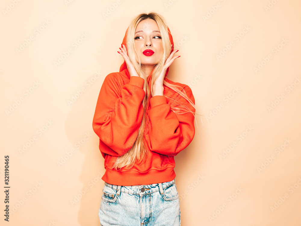 Portrait of young beautiful hipster bad girl in trendy red summer hoodie and earring in her nose.Sexy carefree blond woman posing in studio.Positive model having fun Portrait of young beautiful hipster bad girl in trendy red summer hoodie and earring in her nose.Sexy carefree blond woman posing in studio.Positive model having fun