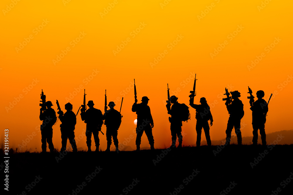 silhouette of Soldier team backdrop of sunset sky.Soldier with machine gun patrolling silhouette of Soldier team backdrop of sunset sky.Soldier with machine gun patrolling