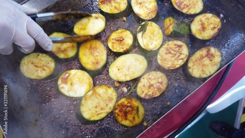 Roasting zucchini slices on a stove.