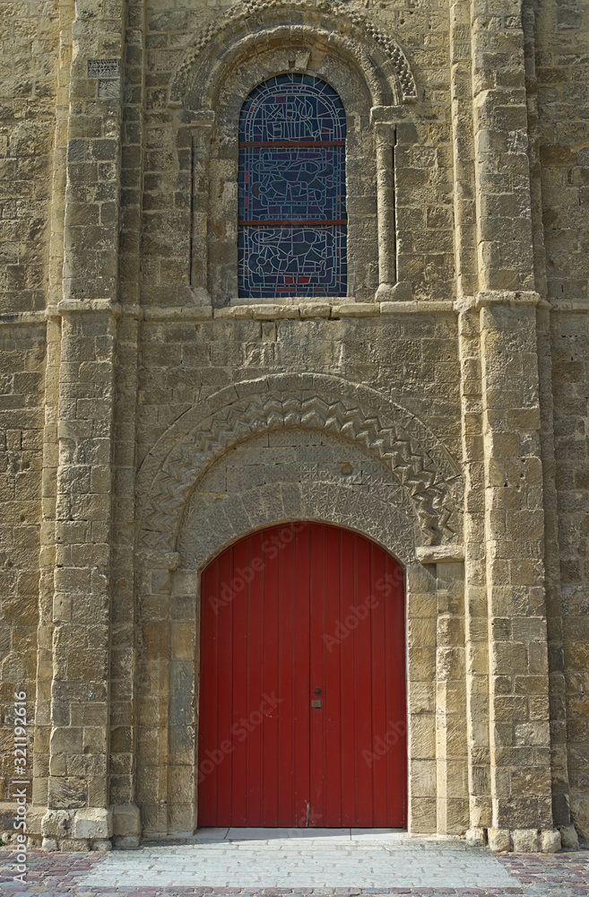 View on red gate and window at gothic style catholic church entrance