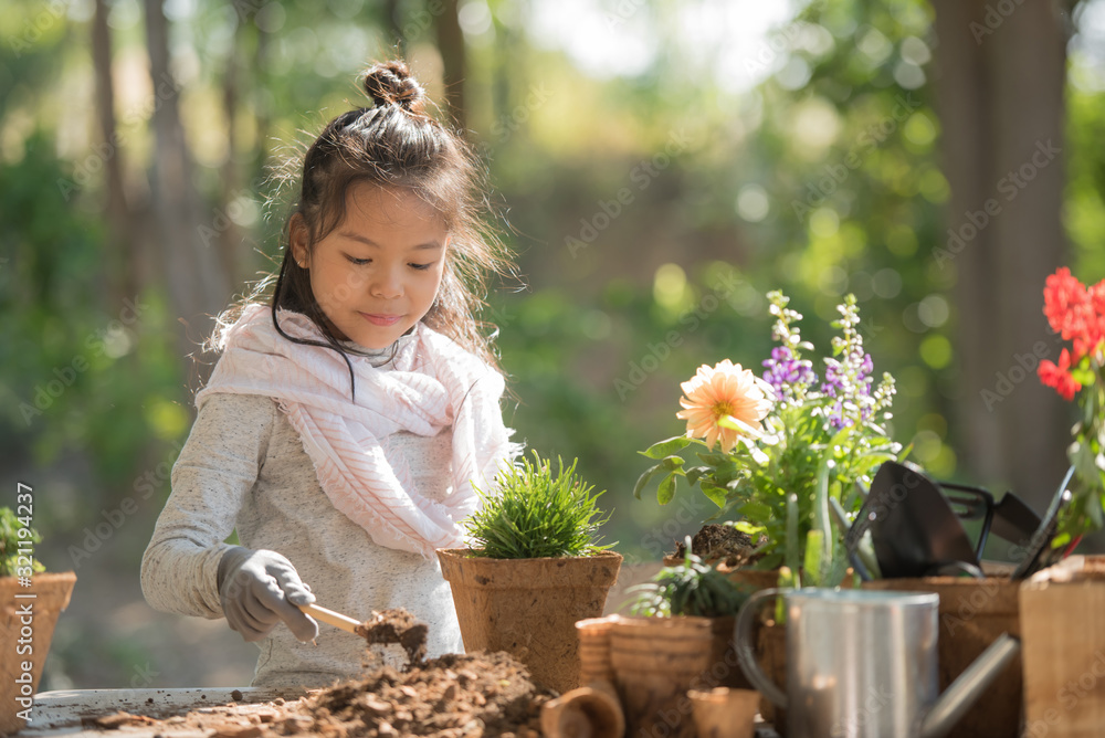 Adorable Asian Little Girl Is Planting Spring Flowers Tree In Pots In Garden Outside House Adorable Asian Little Girl Is Planting Spring Flowers Tree In Pots In Garden Outside House