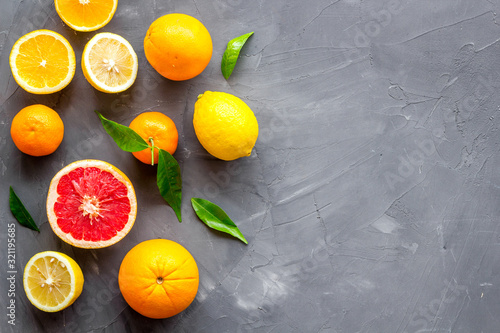 Citrus fruits frame - halfs of lemons, grapefruits, leaves - on grey background top-down copy space © 9dreamstudio