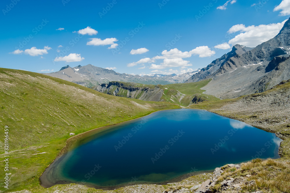Panoramic view over blue alpine lake in the mountains of Vanoise National Park, French Alps, France.