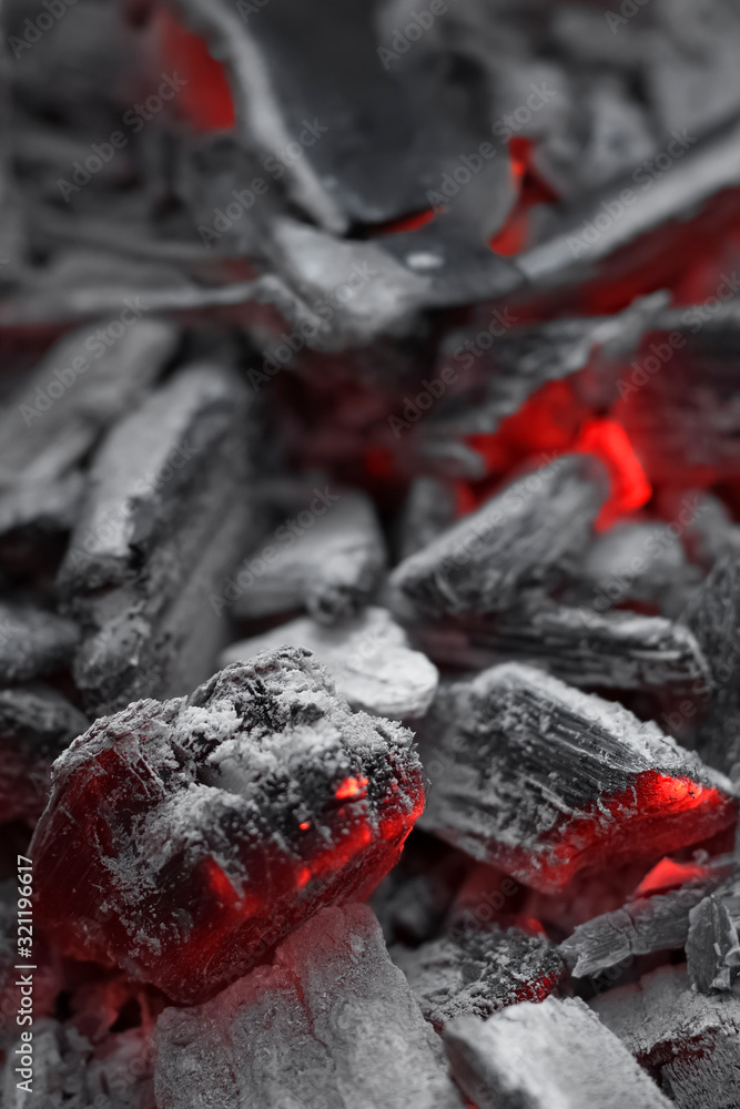 Closeup side view of bright smoldering charcoals in a bonfire with shallow depth of field. Abstract modern trendy texture background Closeup side view of bright smoldering charcoals in a bonfire with shallow depth of field. Abstract modern trendy texture background