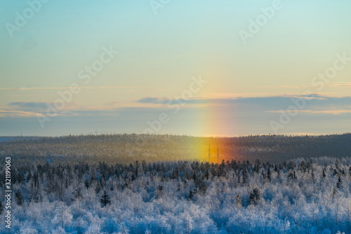 Snowy winter rainbow at   halo  dawn in the polar Russia.