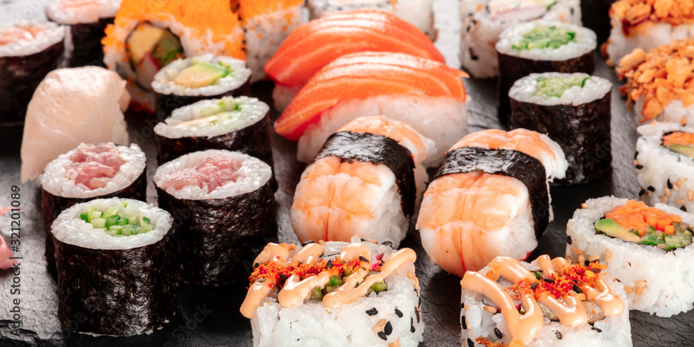 Large sushi set panorama, close-up. An assortment of various maki, nigiri and rolls Large sushi set panorama, close-up. An assortment of various maki, nigiri and rolls