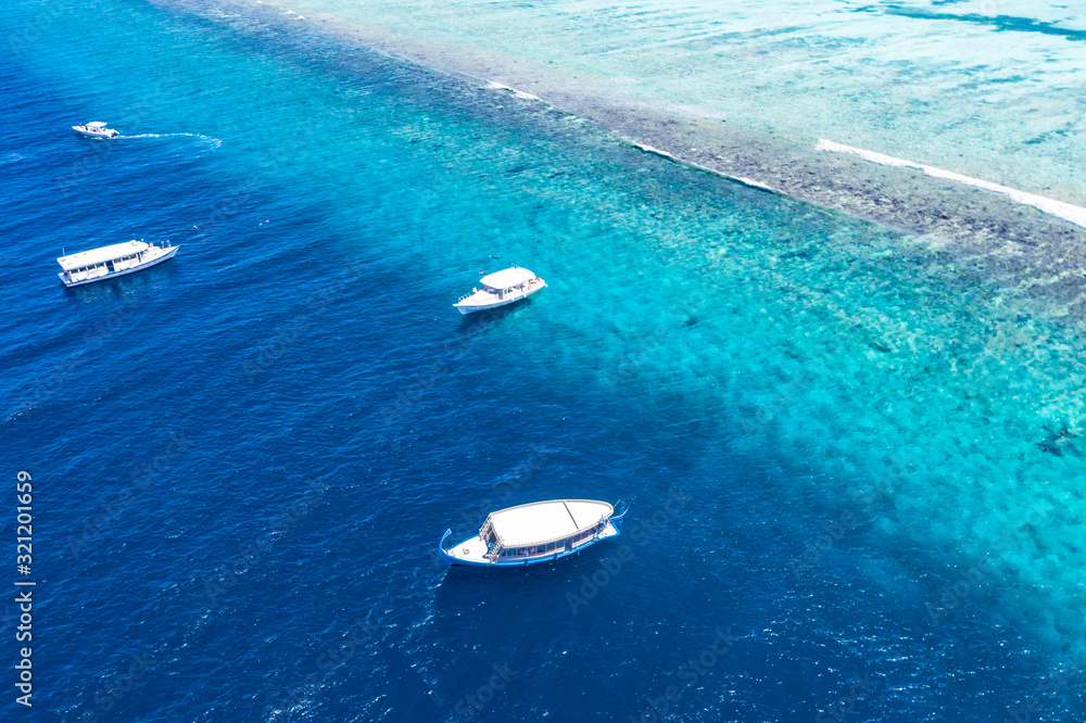 Beautiful turquoise ocean water with boats on it top view aerial photo. Maldives island and sea, amazing aerial photo. Wonderful landscape scenery, exotic travel landscape, summer vacation, holiday Beautiful turquoise ocean water with boats on it top view aerial photo. Maldives island and sea, amazing aerial photo. Wonderful landscape scenery, exotic travel landscape, summer vacation, holiday