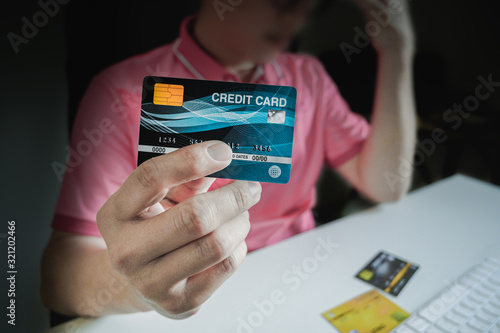 Man paying with credit cards on computer at home.