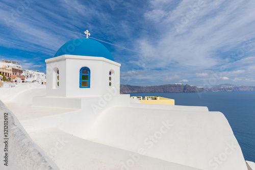 Greek church with blue dome near the sea in Oia town, Santorini island, Greece