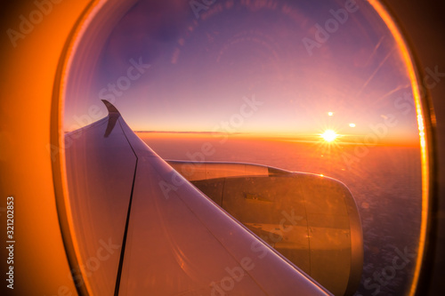 Sunset sky from the airplane window. View on the sunset and airplane wing from the inside © icemanphotos
