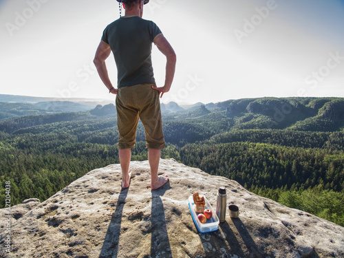 Resting man stay without shoes on view point. Tourist brink