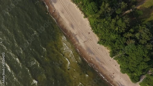 Beautiful cinematic aerial footage of baltic sea coast line with white sand beaches and pine tree forest, not far from Klaipeda city, Lithuania. photo