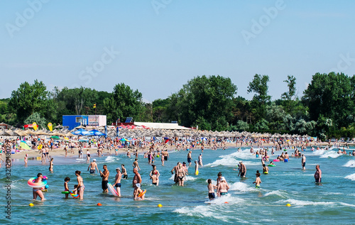 Sandy beach scene of many people suntanning, relaxing and enjoying the shore in summer day. many people have fun in the sea. summer vacation. Mallorca, Spain, August 12, 2019.