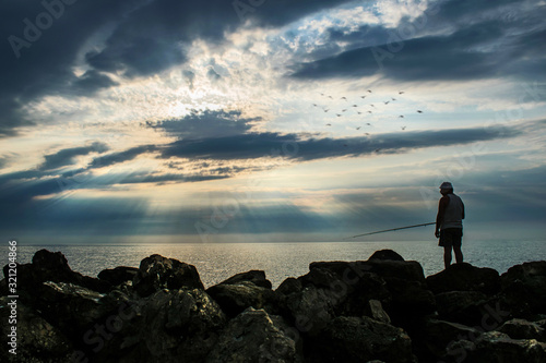 fisherman on the sea shore, at sunrise. Beautiful landscape in a resort on the Romanian coast. 