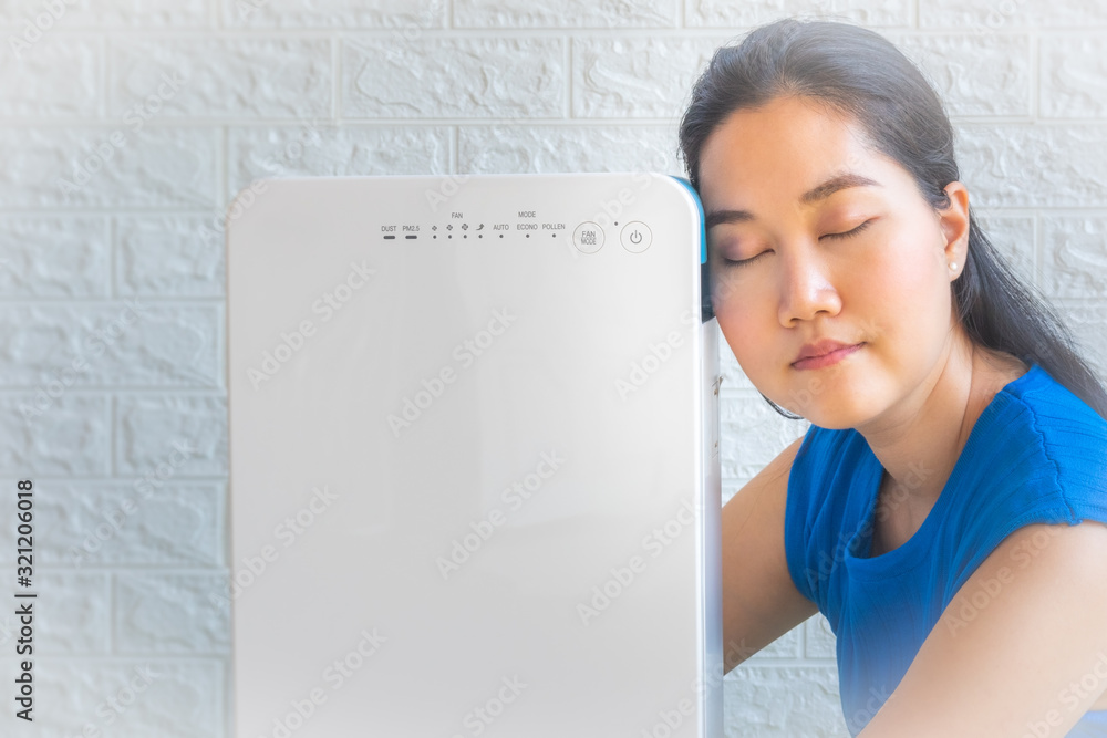 Foto de Asian women sitting beside the air purifier close up. Pollution and unhealthy life