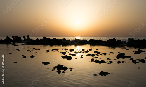 a beautiful sunrise at the sea. Boat and rocks near the shore