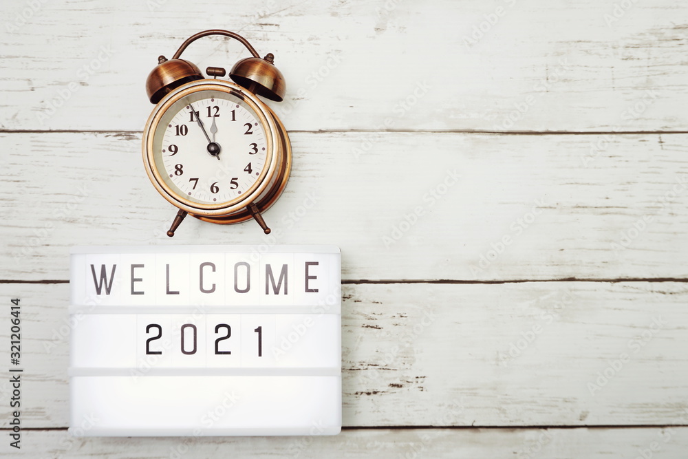 Welcome 2021 text in light box with space copy on wooden background Welcome 2021 text in light box with space copy on wooden background