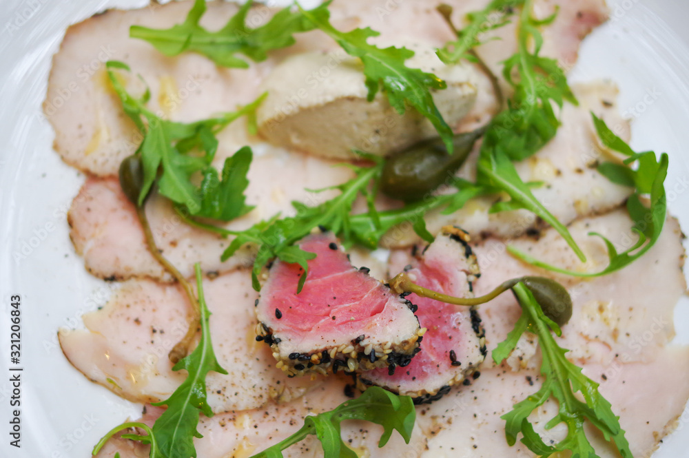 Sesame seared tuna fish meat, foie gras on slices of chicken ham top view