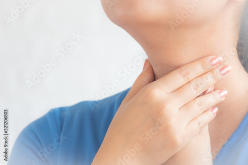 Throat pain. Woman holding her inflamed throat sick woman with sore throat  portrait of woman suffering from cold  flu  sickness with sore throat inflammation  Medical concept.