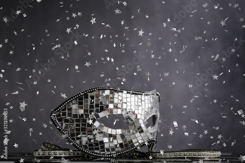 Fototapeta Naklejka Na Ścianę i Meble -  Maschera d'argento sopra la scacchiera bianca e nera con coriandoli  e cristalli