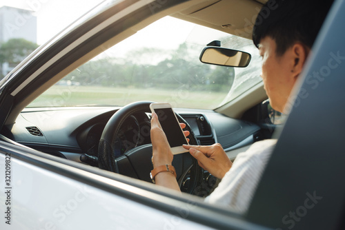Man driver using smart phone in car