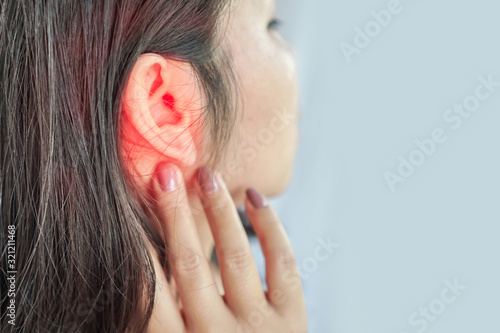woman suffering from ear pain , Tinnitus concept photo
