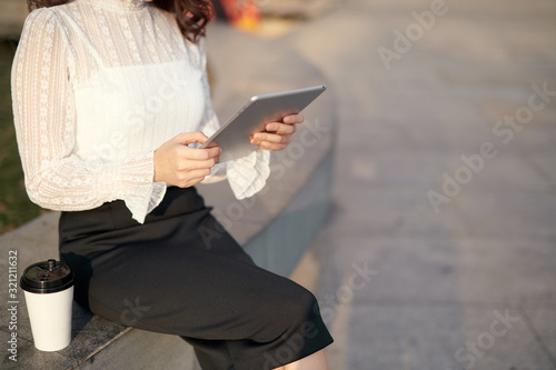 Beautiful Asian woman using tablet computer outdoor in the city to complete her own business. Online business concept
