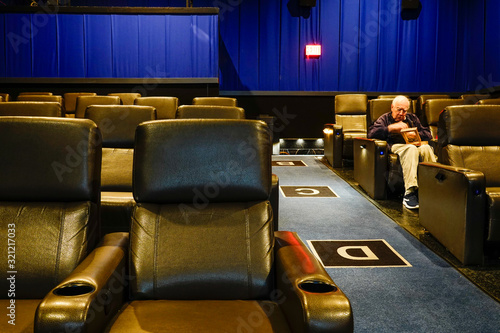 Prince Fredrik, Maryland USA A senior man sits alone in a movie theatre. photo