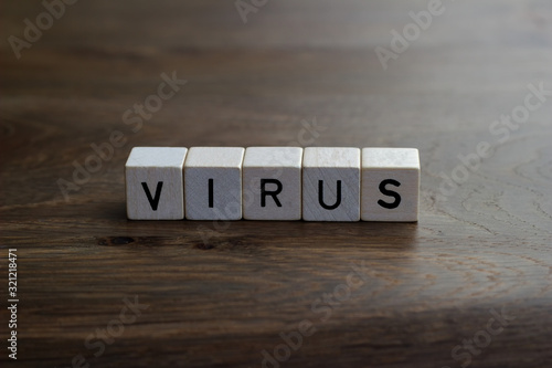 VIRUS text from letter cubes, Brown wood background.