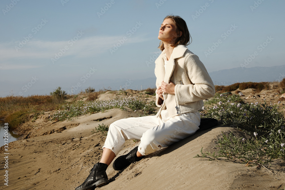 Young woman enjoying time on the winter beach. Outdoors.