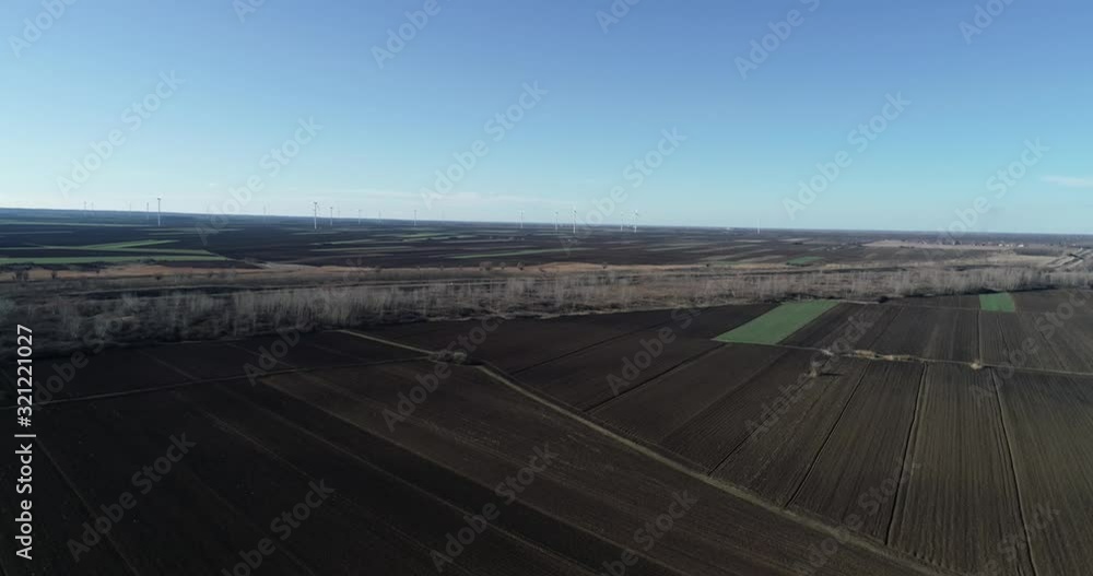 Aerial View of Sketchy Agricultural Farming Fields in Countryside of Serbia With Overview of Wind Turbines in Background Aerial View of Sketchy Agricultural Farming Fields in Countryside of Serbia With Overview of Wind Turbines in Background